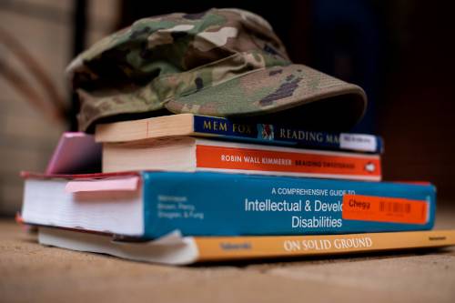 Army hat resting on top of college textbooks